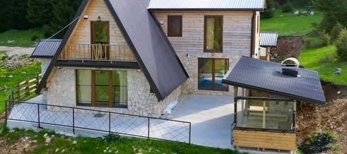 Villa Suvo Vrelo — moderna drvena planinska vila sa kamenom fasadom, okružena livadom i četinarskom šumom
